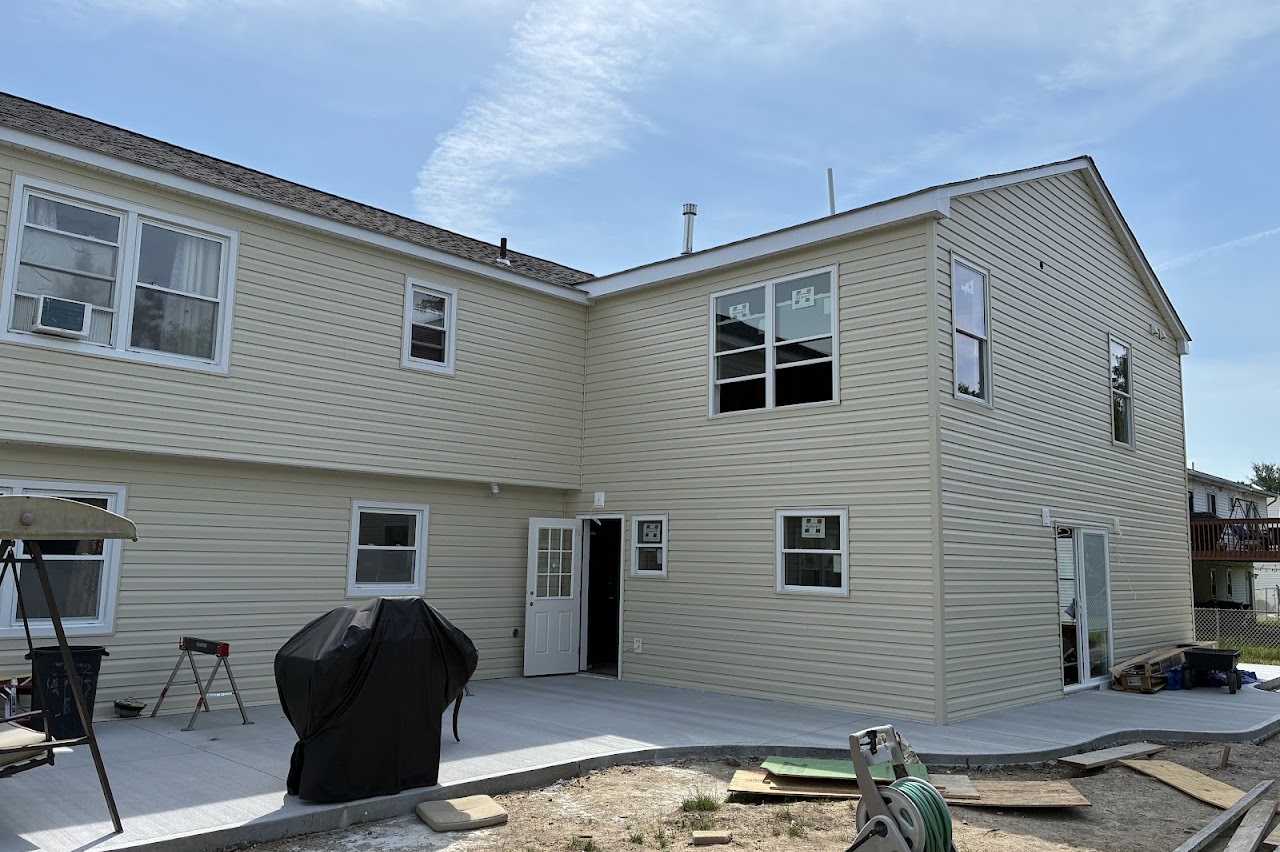 The rear of a finished home with a bluestone patio and new lawn
